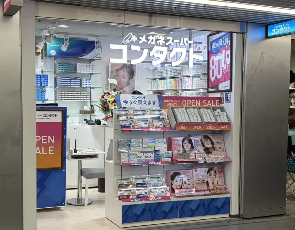 メガネスーパーコンタクトしぶちか店の外観。店頭にアウトレットのカラーコンタクトが並べてある。クリアレンズの価格表も並べてある。