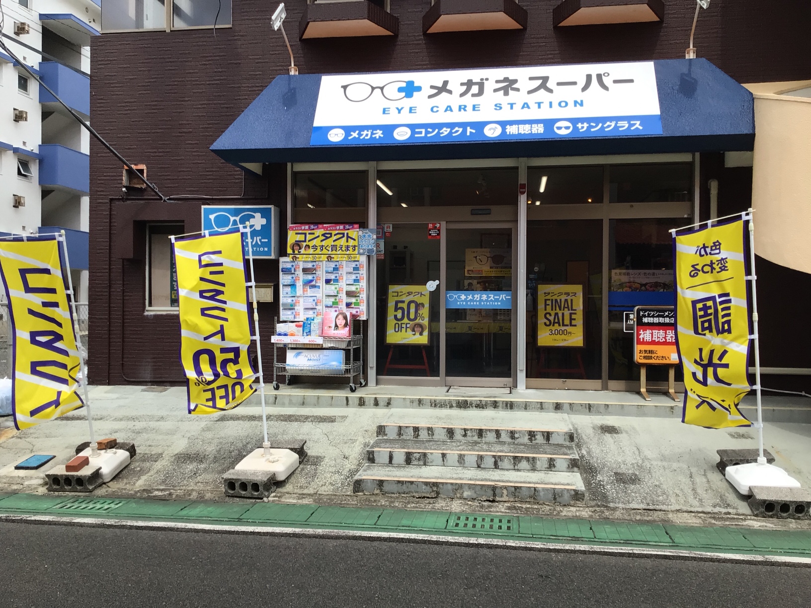 メガネスーパー徳之島店の外観、コンタクト商品が⾒える⼊⼝