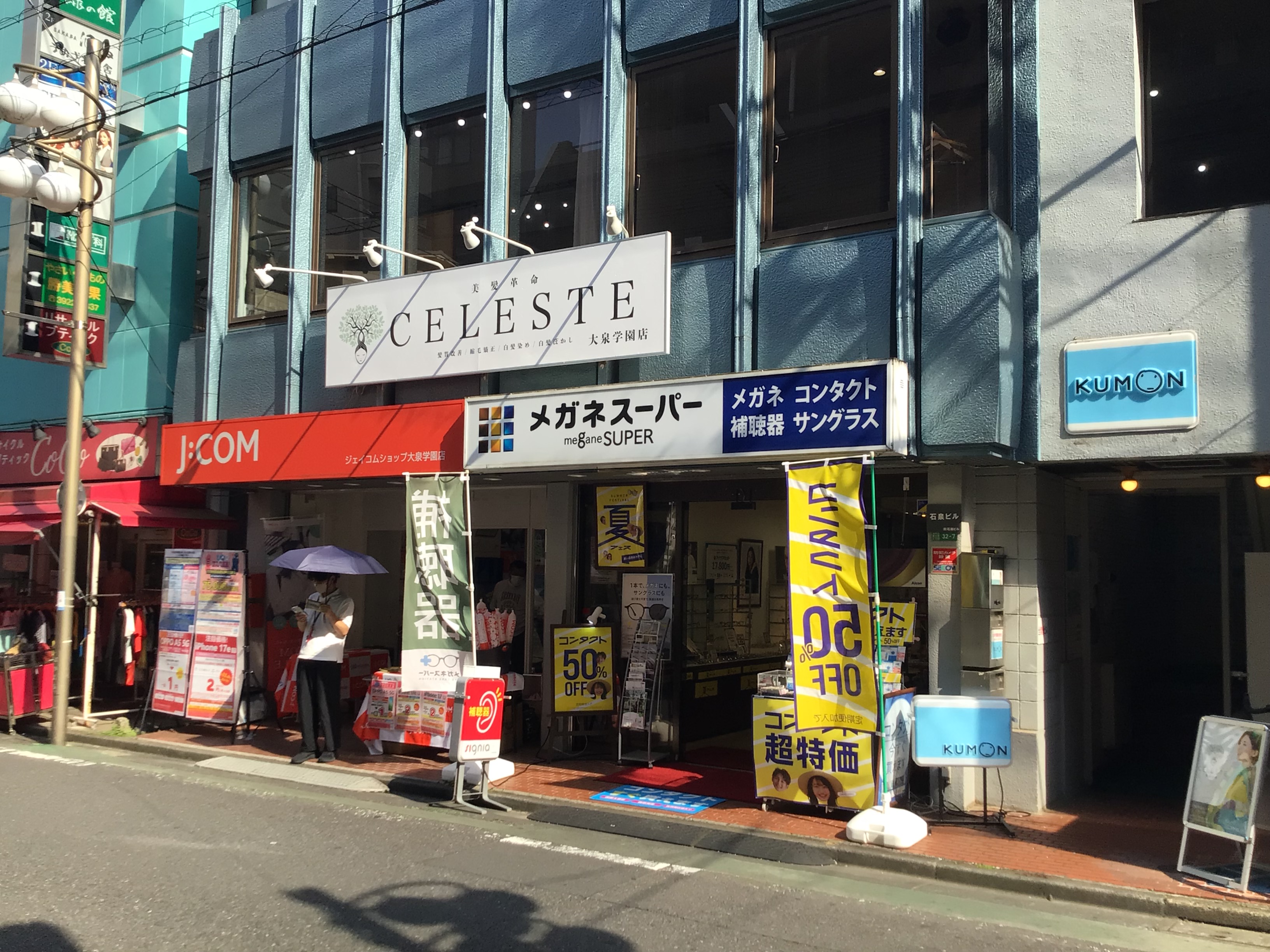 メガネスーパー大泉学園店の外観、ビルの1階　白と青の欄間看板