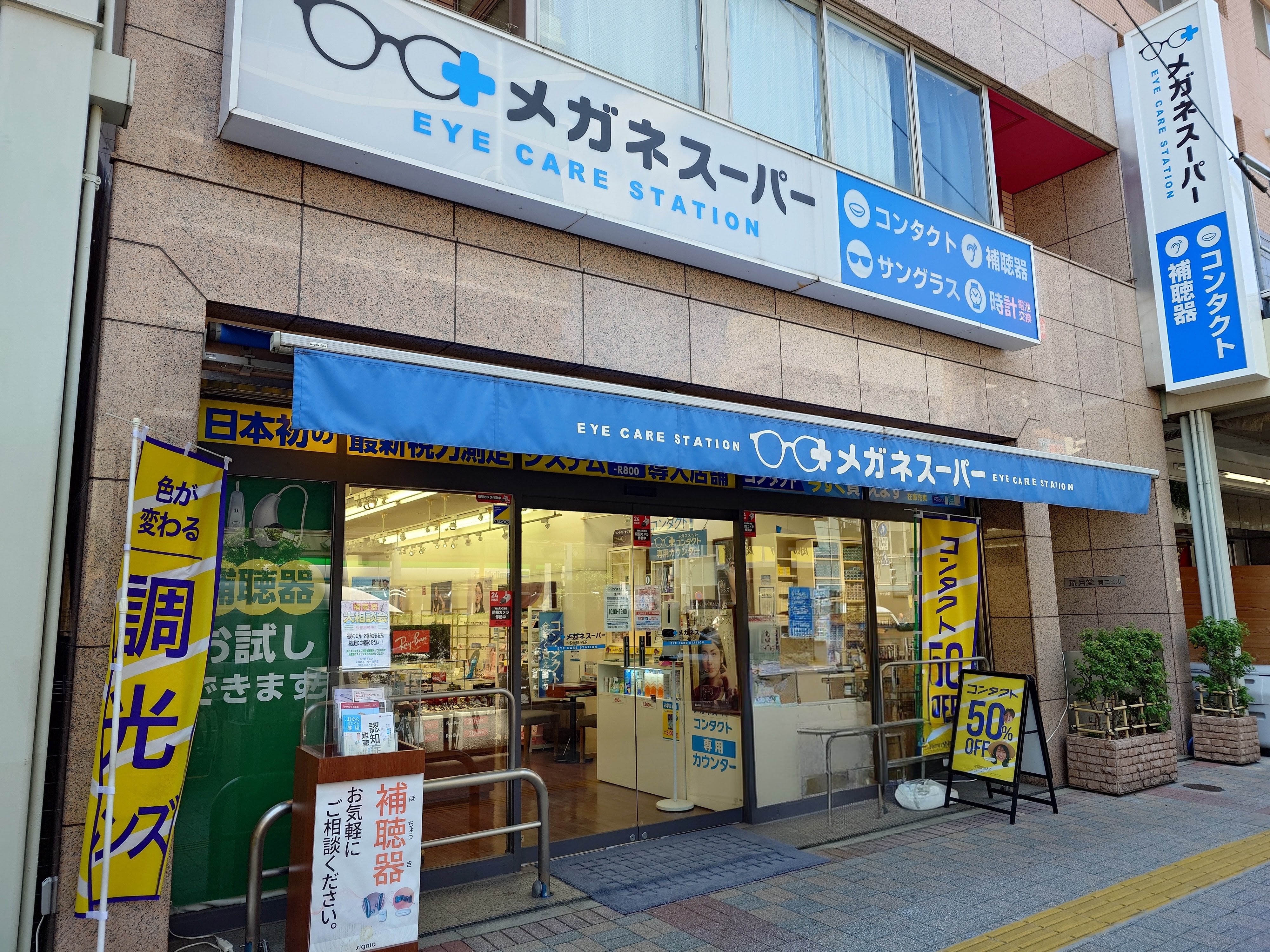 メガネスーパー亀戸店の外観　メガネやコンタクトレンズ、補聴器などのPOPが見える入り口